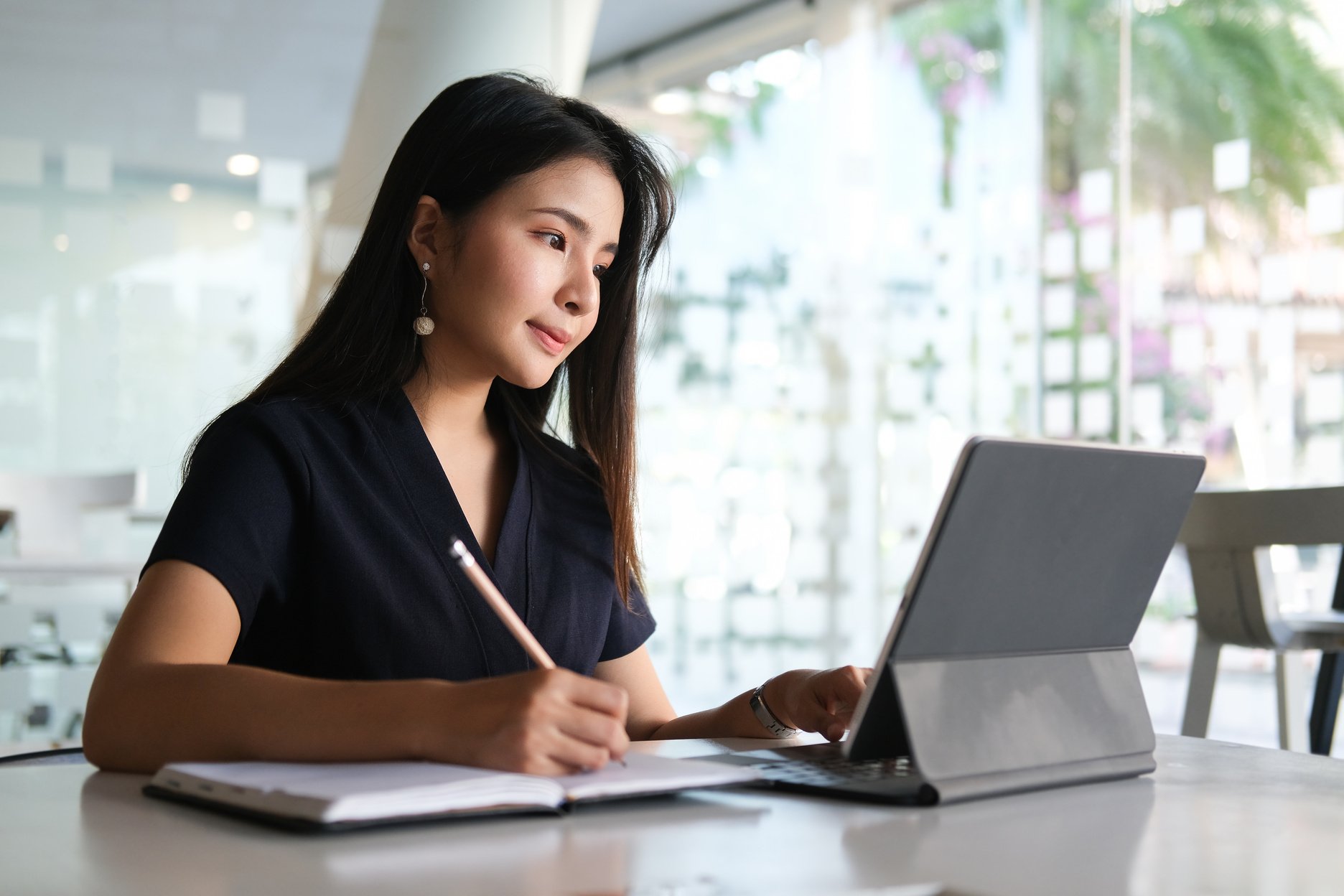 A Young Female Administrative Assistant Making Notes of Working